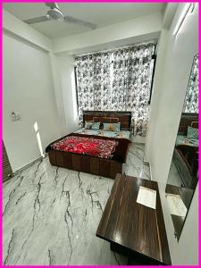 马图拉HOTEL PREMIUM SHRI PRABHU DHAM Near Temple VRINDAVAN的一间卧室，里面有一张床、一张桌子和一扇窗户