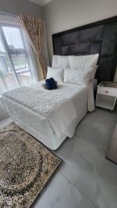 a stuffed animal laying on a bed in a bedroom at Ee40Yethu in Pretoria