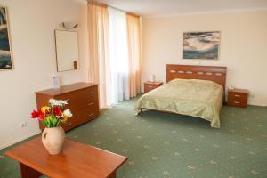 a bedroom with a bed and a table with a vase of flowers at VILA DORULUI in Molovata Nouă