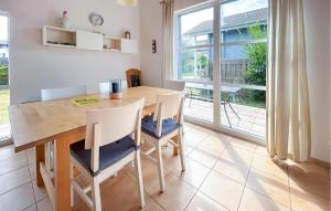 a dining room with a table and chairs and a window at Seebrise in Süssau