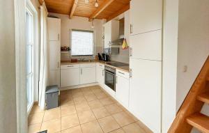 a small kitchen with white cabinets and a window at Seebrise in Süssau