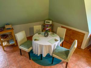 a table with chairs and a vase of flowers on it at Ferienwohnung Locke in Kluis +6 photos
