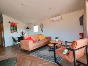 a living room with a couch and a table at Nieuwe Luxe Lodge met Weidezicht - bij Nationaal park Drents-Friese Wold in Hoogersmilde