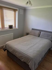 a bedroom with a large white bed with two windows at Wick Apartment in Wick +10 photos