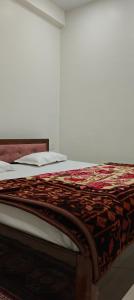 AyodhyaにあるJanki Paying Guest Houseのベッド(上に掛け布団付)