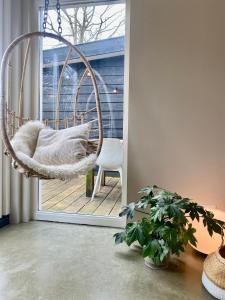 a swinging chair in a room with a window at Holiday home De Heer van Bergen in Bergen