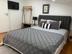 a bedroom with a bed with a black and white comforter at Apartamento Deluxe II RB in Ribeira Brava