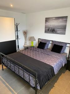 a bedroom with a large bed with purple sheets and a painting at Charmant appartement 3 étoiles entièrement rénové "U Nidu" vue sur le Golfe de Valinco à Viggianello in Viggianello