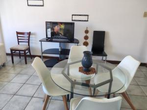 a dining room with a glass table and white chairs at 406 Seabrook in Margate