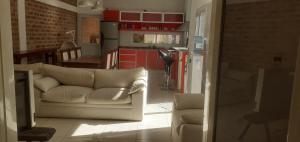 a living room with a white couch and a kitchen at María del Valle Alojamientos in Belén