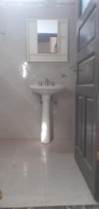 a white bathroom with a sink and a mirror at María del Valle Alojamientos in Belén