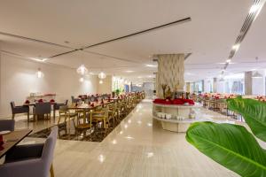 a restaurant with tables and chairs and red flowers at Diamond Bay Hotel in Nha Trang