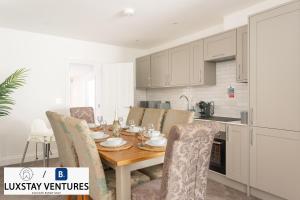 a kitchen and dining room with a wooden table and chairs at Bright and Spacious 2BR Maisonette Sleeps 8, Game Room, 5 mins to Brighton Beach and City Centre in Brighton & Hove +37 photos