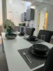 una mesa con placas negras y un jarrón de flores. en The Netflix Suite, en Leicester