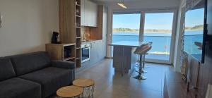 a living room with a couch and a view of the ocean at APARTMAN SUNSIDE2 NIN in Nin