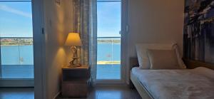 een slaapkamer met een bed en uitzicht op het water bij APARTMAN SUNSIDE2 NIN in Nin