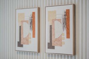 two picture frames hanging on a wall at The AlJada Studio by Blue Cloud Holidays in Sharjah