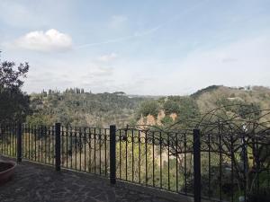 een smeedijzeren hek met uitzicht op een vallei bij La loggia del pappagallo in Gallese