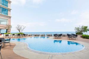 a swimming pool with tables and chairs next to a building at Diamond Bay Hotel in Nha Trang