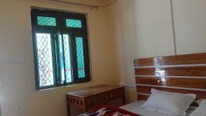 a bedroom with a bed and a window at Tritiya kedar home stay in Rudraprayāg
