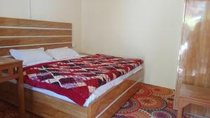 a bedroom with a bed with a quilt on it at Tritiya kedar home stay in Rudraprayāg