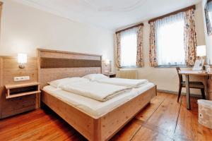 a bedroom with a large bed and a desk at Löwen Hotel & Restaurant in Marktbreit
