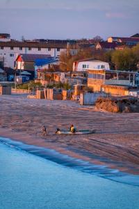two people playing on a beach near the water at Casa din Vamă in Vama Veche