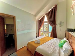 Postel nebo postele na pokoji v ubytování Quang Minh Dalat Hotel