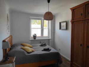 a bedroom with a bed with a window and a lamp at Apartament Baltic Ustka in Ustka