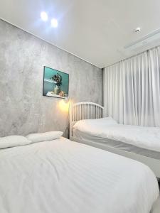 a bedroom with two beds and a wall at Rest house in Goyang