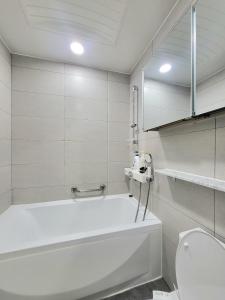 a white bathroom with a tub and a toilet at Rest house in Goyang +63 photos