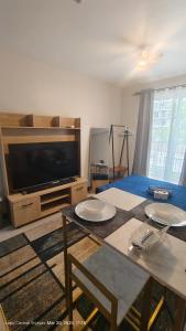 a living room with a table and a large television at Be Housed Studio Bldg 302 in Lapu Lapu City
