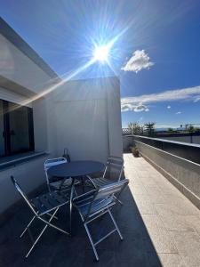 a table and chairs on a balcony with the sun at Piccolo attico a Prato in Prato