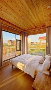 a large bed in a room with a large window at MuseNomad Retreat in Honukay