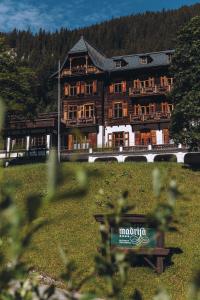 ein großes Holzgebäude mitten auf einem Feld in der Unterkunft Hotel Madrisa in Gargellen