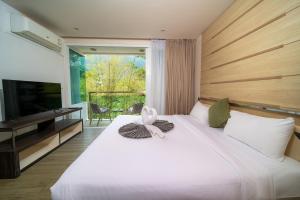 a bedroom with a large white bed with a flower on it at A New Experience of Private Vacation and Work in Patong in Patong Beach +37 photos