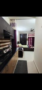 a room with a kitchen and a bedroom with a bed at The Nainital Luxury Cotteges in Bhowāli