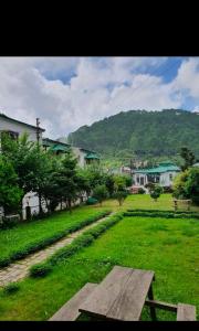 a picnic table in a field of green grass at The Nainital Luxury Cotteges in Bhowāli +14 photos