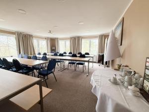 a meeting room with tables and chairs in a room at Strandhotel Vier Jahreszeiten Buckow in Buckow