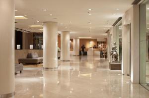 una hall con colonne e divani in un edificio di The Royal Garden a Hong Kong Altre 33 foto