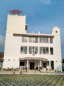 a white building with a clock tower on top at Hotel Annapurna Regency in Mirzāpur