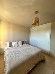 Un dormitorio con una cama grande y una lámpara de araña. en Terra Palm Golf Apartment 3, en Las Casicas