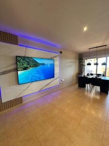 comedor con TV grande en la pared en Terra Palm Golf Apartment 3, en Las Casicas