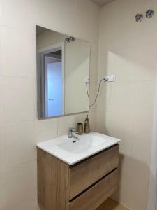 un baño con lavabo y espejo en Terra Palm Golf Apartment 3, en Las Casicas