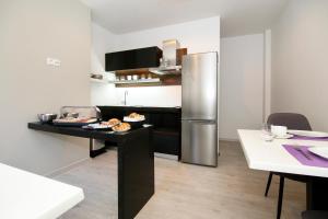 a kitchen with a refrigerator and a table with food at Maxim Deluxe Rooms with Balcony & Private Bathrooms - Downtown Spalato, Quiet Neighborhood in Split