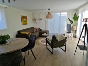 a living room with a couch and a table at Chalet T18 in Makkum
