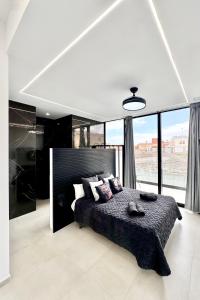 ein Schlafzimmer mit einem großen Bett und einem großen Fenster in der Unterkunft Luxury Villa in Melenara in Las Palmas de Gran Canaria + 32 Fotos