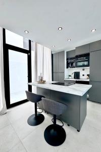 eine Küche mit Theke und zwei Barhockern in der Unterkunft Luxury Villa in Melenara in Las Palmas de Gran Canaria