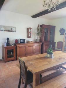 a dining room with a wooden table and a kitchen at Château de la Rucquetière in Le Lorey
