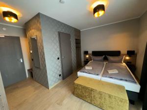 罗斯托克Pension Meeresluft的一间大卧室,配有一张大床和一张长凳